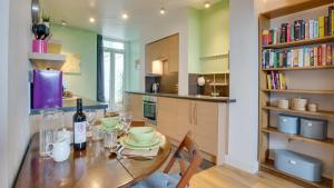 a kitchen with a table with a bottle of wine at Mumbles Rd Apartment in The Mumbles