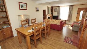 a living room with a wooden table and a dining room at Oyster Cottage in The Mumbles