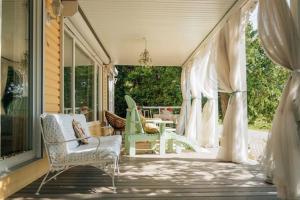 un porche con sillas y una mesa en una casa en Hot Tub Waterfront Cottage - Near Sauble beach, en Wiarton