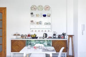 een witte keuken met een tafel en borden aan de muur bij Mencin in Carloforte