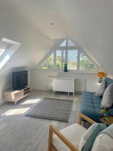 sala de estar con sofá azul y TV en Cosy accommodation, easy walk to beach!, en Barton-on-Sea