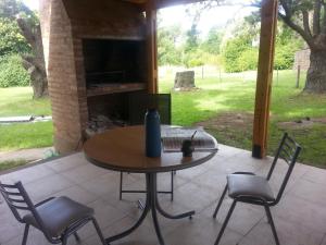 a table and chairs on a patio with a fireplace at La Posada del Hobbit in Villa Ventana +12 photos