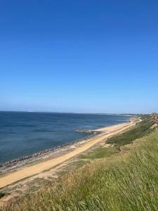 uma vista para uma praia com o oceano em Cosy accommodation, easy walk to beach! em Barton on Sea