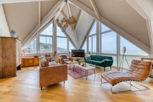 费康Le poséidon, gîte EXCEPTIONNEL face à la mer avec spa, terrasse, 4 chambres UN VRAI COUP DE COEUR的阁楼客厅设有许多窗户。
