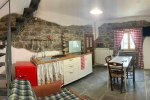 a kitchen with a table and a stone wall at Casa Vacanza Contado Latino in Belmonte del Sannio