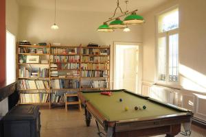 Habitación con mesa de billar y estantería. en Petit château à la campagne., en Beloeil