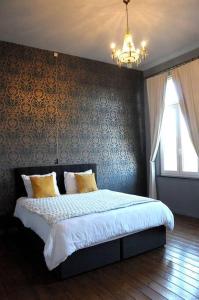 - une chambre avec un lit et un lustre dans l'établissement Petit château à la campagne., à Beloeil