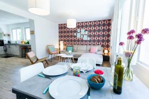 a dining room and living room with a table at La Villa Capuccine in Nîmes