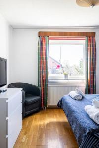1 dormitorio con 1 cama, 1 silla y 1 ventana en Quiet Rum in Swedish villa, en Huddinge
