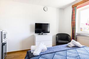 a bedroom with a bed and a tv and a chair at Quiet Rum in Swedish villa in Huddinge