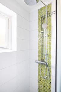 a bathroom with a shower with a mosaic tile wall at Quiet Rum in Swedish villa in Huddinge