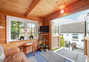 a living room with a couch and a large window at Forget-me-not Bungalow in Seaton