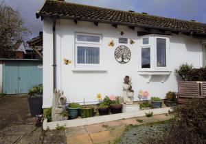 a white house with a statue in front of it at Forget-me-not Bungalow in Seaton