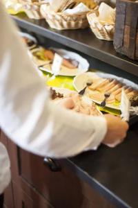 una persona sosteniendo un plato de comida en un mostrador en Eksjö Stadshotell, en Eksjö