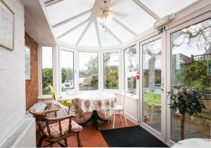 a conservatory with a table and chairs at Knowles in Colyton