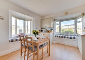 uma cozinha e sala de jantar com mesa e cadeiras em Marnies View em Sidmouth