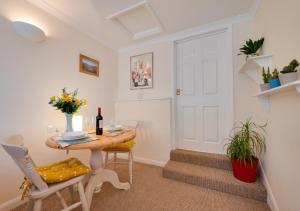 a room with a table and chairs and a white door at Little Hollies in Salcombe Regis