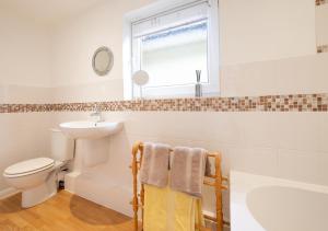 a bathroom with a sink toilet and a window at Little Hollies in Salcombe Regis