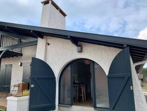 a house with green doors and a black roof at La Rose Trémière in Parentis-en-Born