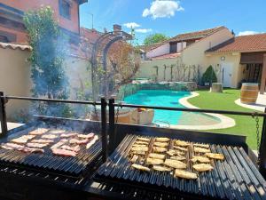 een grill met vlees en een zwembad in een tuin bij La Casa del Solaz in Anaya