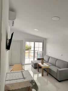 uma sala de estar com um sofá e uma mesa em Vila SUN 2E em Ksamil