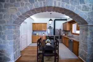 Villa S'Olioni في Loceri: مطبخ مع طاولة وجدار حجري