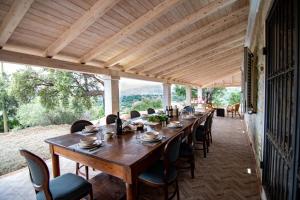 Villa S'Olioni في Loceri: طاولة خشبية طويلة وكراسي على الفناء