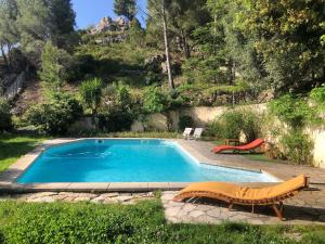 uma piscina com uma mesa e um banco ao lado em L’appartement - Jardin Secret em Marselha
