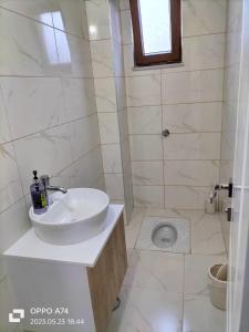 a white bathroom with a sink and a toilet at TRABZON-AKÇAABAT/MERSİN in Vartara