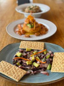 two plates of food on a wooden table at El Refugio de Vichayito in Vichayito