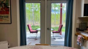 a room with a door open to a patio with chairs at The Big Red Barn in Whitehorse