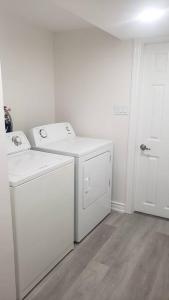 a white laundry room with a washer and dryer at An Ideal Apartment for you. in Brampton