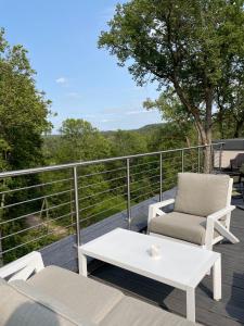 a patio with a white coffee table and chairs on a deck at Hotel "Senleja" in Sigulda