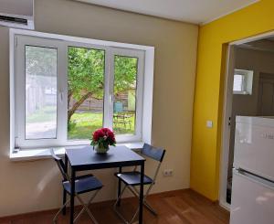 a dining room with a table and two windows at Sadama Stay in Haapsalu