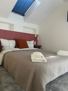 a bedroom with a large bed with a red headboard at THEIA - Limoges Centre in Limoges