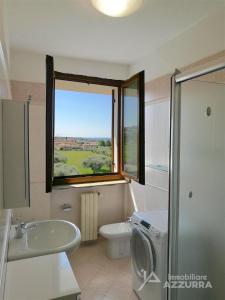 バルドリーノにあるLa Terrazza sul Lago - Immobiliare Azzurraのバスルーム(洗面台、トイレ付)、窓が備わります。