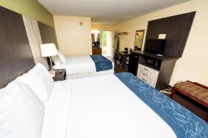 a hotel room with two beds and a television at River Place Inn in Pigeon Forge