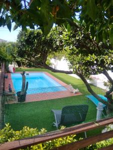 Blick auf den Pool durch einen Zaun in der Unterkunft 4 bedrooms villa with private pool enclosed garden and wifi at Bellvei 6 km away from the beach in Bellvei del Penedes