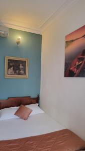 1 dormitorio con 1 cama y una foto en la pared en Villa Eden, en Niza