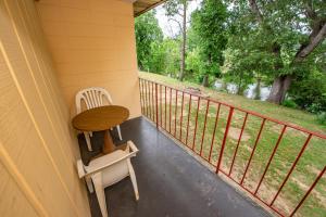 a porch with a table and a chair and a fence at River Place Inn in Pigeon Forge +38 photos