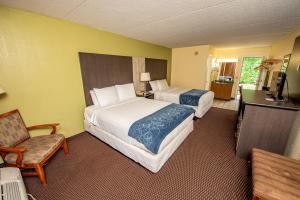 a hotel room with two beds and a chair at River Place Inn in Pigeon Forge