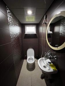 a bathroom with a toilet and a sink and a mirror at Family Hotel Keti in K'obulet'i +19 photos