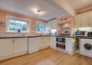 a large kitchen with white cabinets and appliances at The Orchard in Seaton