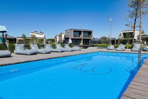 a blue swimming pool with pillows around it at Season Surprise Apartment, By Cohost in Palanga
