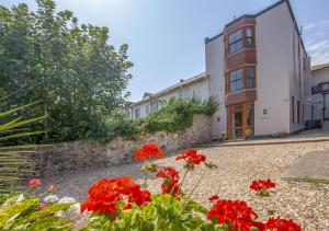 a garden with red flowers in front of a building at Sovereign in Seaton