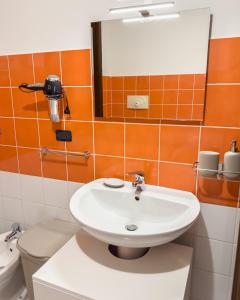 ein Badezimmer mit einem Waschbecken, einem WC und einem Spiegel in der Unterkunft Aurelia Casa Vacanze in Mirabella Eclano
