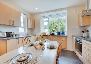 a kitchen with a table and chairs in a kitchen at Tay Craig in Sidmouth