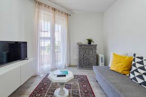 uma sala de estar com um sofá e uma televisão em Setubal Downtown Garden em Setúbal