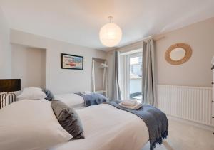 a bedroom with two beds and a window at April Cottage in Brixham