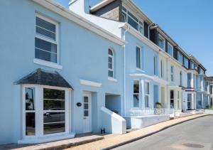 a row of white buildings on a street at April Cottage in Brixham